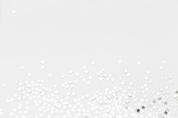 Silver confetti and stars and sparkles on a light background. Top view, flat lay. Copy text. holiday background. For Christmas, New Year, Valentine's Day