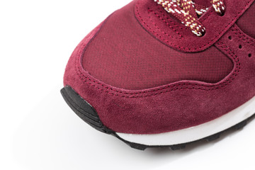 a pair of new burgundy, cherry sneakers or athletic shoes isolated on a white background.