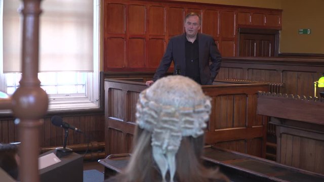 Female Barrister / Lawyer talking in Court. She is wearing a wig and gown in the Courtroom. Close up