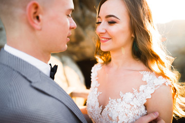 Beautiful bride with a bouquet on mountain background at sunset