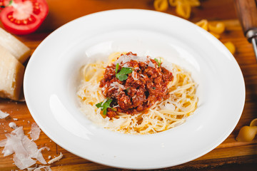Spaghetti bolognese with tomato sauce, minced meat and grated parmesan cheese. Italian pasta.
