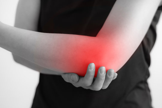 A woman holding hands. Pain in the elbow. The hearth is highlighted in red. Close up. Isolated background