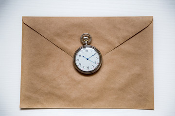  round clock on the background of a paper envelope