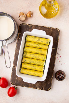 Raw cannelloni, uncooked Italian pasta in baking dish. Cooking, making process