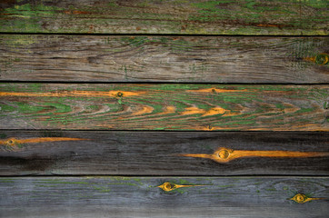 Battered, faded old horizontal wooden planks with splotches of knots and remnants of green paint....