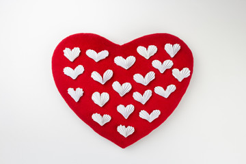Small white paper hearts on a big soft red heart.