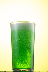 pour green carbonated tarragon lemonade in a glass with ice, flow and stream