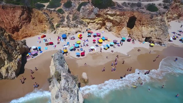 Aerial top view of tourists resting on the beach Alemao Vau, Boia, tres irmaos, Portimao Algarve coast. Portugal.