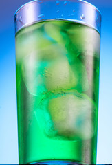 misted glass with green carbonated drink tarragon and cubes of real ice