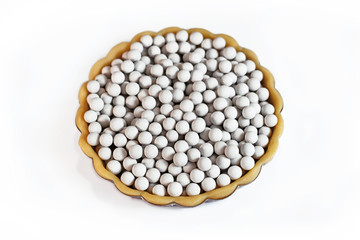 Top view of unbaked tart filled with ceramic pie weights used to keep crust from shrinking during...