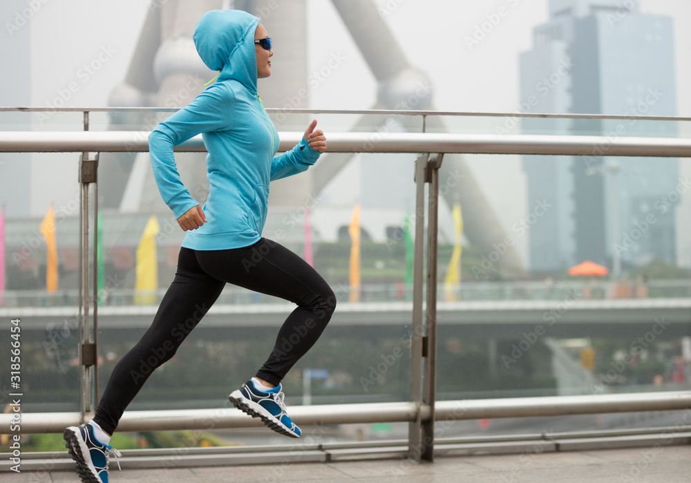 Poster Young fitness woman runner running at shanghai city