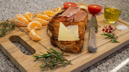 Mediterranean breakfast. Toast with ham and cheese and others ingredients, rustic and healthy.