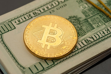 Close-up of a silver bitcoin coin lies on bills