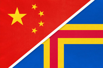 China or PRC vs Aland Islands national flag from textile. Relationship between asian and european countries.
