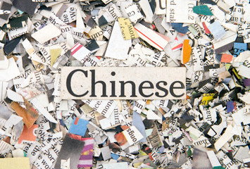 Newspaper confetti from above with the word Chinese