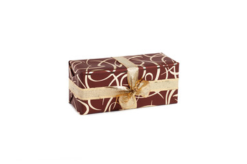 packaged rectangular gift in dark brown packaging with gold bow and gold pattern on the white background