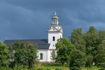Fototapeta na wymiar White church in a lush green environment