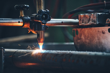Plasma cutting machine cutting steel pipe with sparks