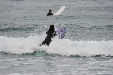 Fototapeta premium Korean Winter surfers at the Buheung-ri beach in Namjeong-Myeon, Yeongdeok-gun, South Korea.