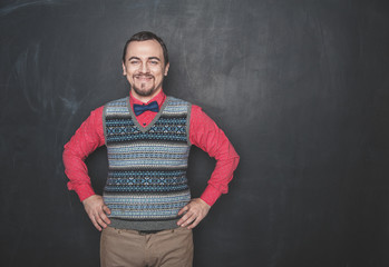 Funny smiling teacher man or businessman on blackboard background