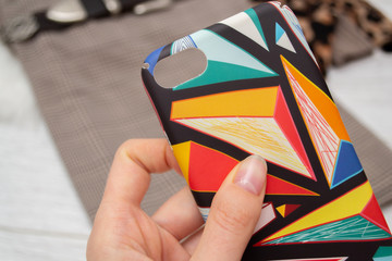 Bright multi-colored case for smartphone close-up on a wooden background