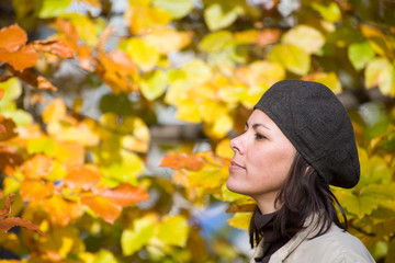 Happy Woman with Hat in Profile with Autumn Leaves.