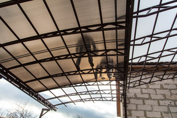 A worker mounts a metal canopy in the courtyard of the house