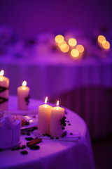 Beautiful, decorated table with flower decorations and red candles. Christmas evening or wedding party decoration.