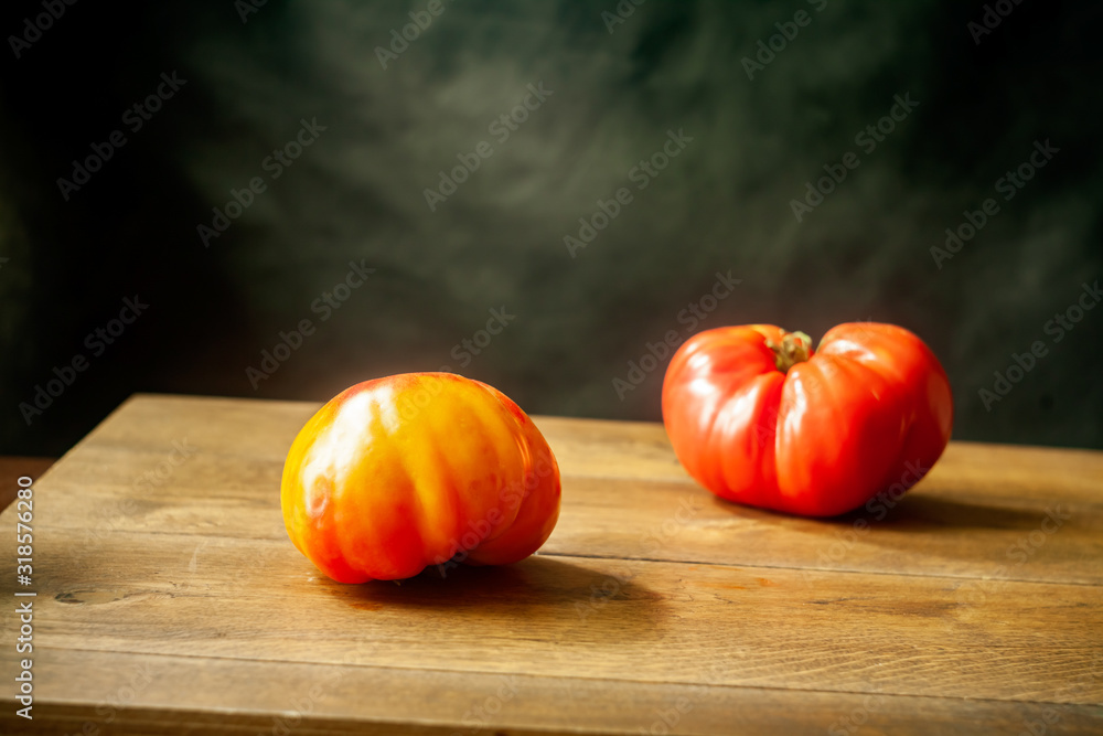 Wall mural still life with 2 juicy ripe tomatoes on a wooden table.