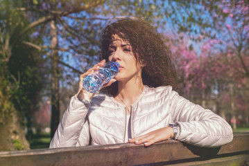 Fototapeta premium Beautiful curly woman drinking water
