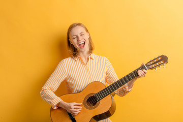 Portrait of young caucasian attractive musician woman in casual shirt, singing with opened mouth....