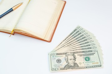 Money, notebook and pen with white background. Isolated