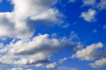 Beautiful fluffy white cumulus clouds in the blue sky. Abstract natural background
