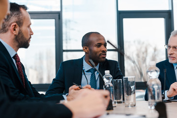 selective focus of handsome multicultural diplomats near microphones