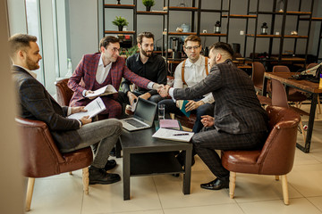 two leaders of diverse business companies shaking hands in office, at the end of effective meeting. young men in formal wear isolated in modern boardroom. business people, success concept