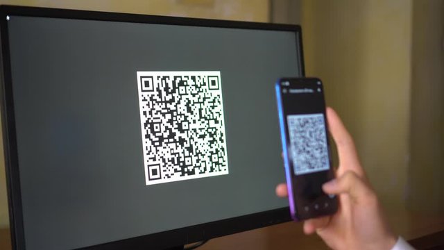 A man scans a QR code from the computer screen. Online Payment, Transfer, Invoicing, Check-in, Website login, Self-service, Participation in promotions, Exchanging information, Booking