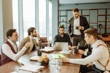 coworking of young business team gathered in office together, discussing and sharing opinons, wearing stylish formal clothes
