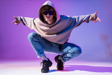 Breakdancing young man in hoodie with hair styling. Dance school poster. Copy space. Battle competition announcement.