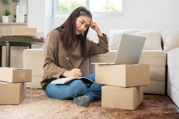 Young asian entrepreneur feeling stress and anxiety resulting from reduced sales after checking orders from customers by laptop. Concept of small business owner. Need a business consultant concept