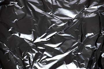Texture of crumpled foil in silver color.