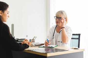 Senior female doctor and patient talking explaining medical informations and diagnosis, Treatment at hospital.