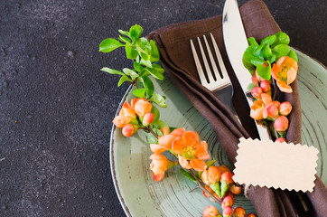 Vintage table setting with delicate flowers and tag on rustic shabby table.