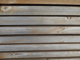 Fototapeta premium Fragment of a wooden fence or bench, parallel boards with peeling paint