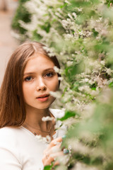 Naklejka premium Happy young girl is enjoying flowering