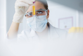 Woman researcher is surrounded by medical vials and flasks, isolated on white