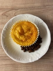 Muffin auf weißem Teller mit Kaffeebohnen