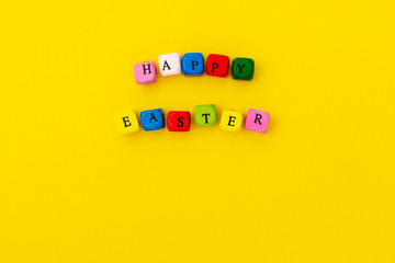 Happy Easter. Cubes with text on yellow background. Ready greating card design for Easter.