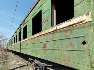 Fototapeta na wymiar Old green passenger train car without glasses. Outside.