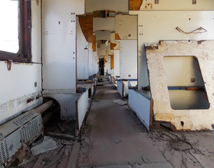 . Old green passenger train car without glasses. Inside.