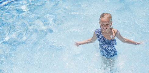 Pretty little girl in swimming pool, summer vacations.